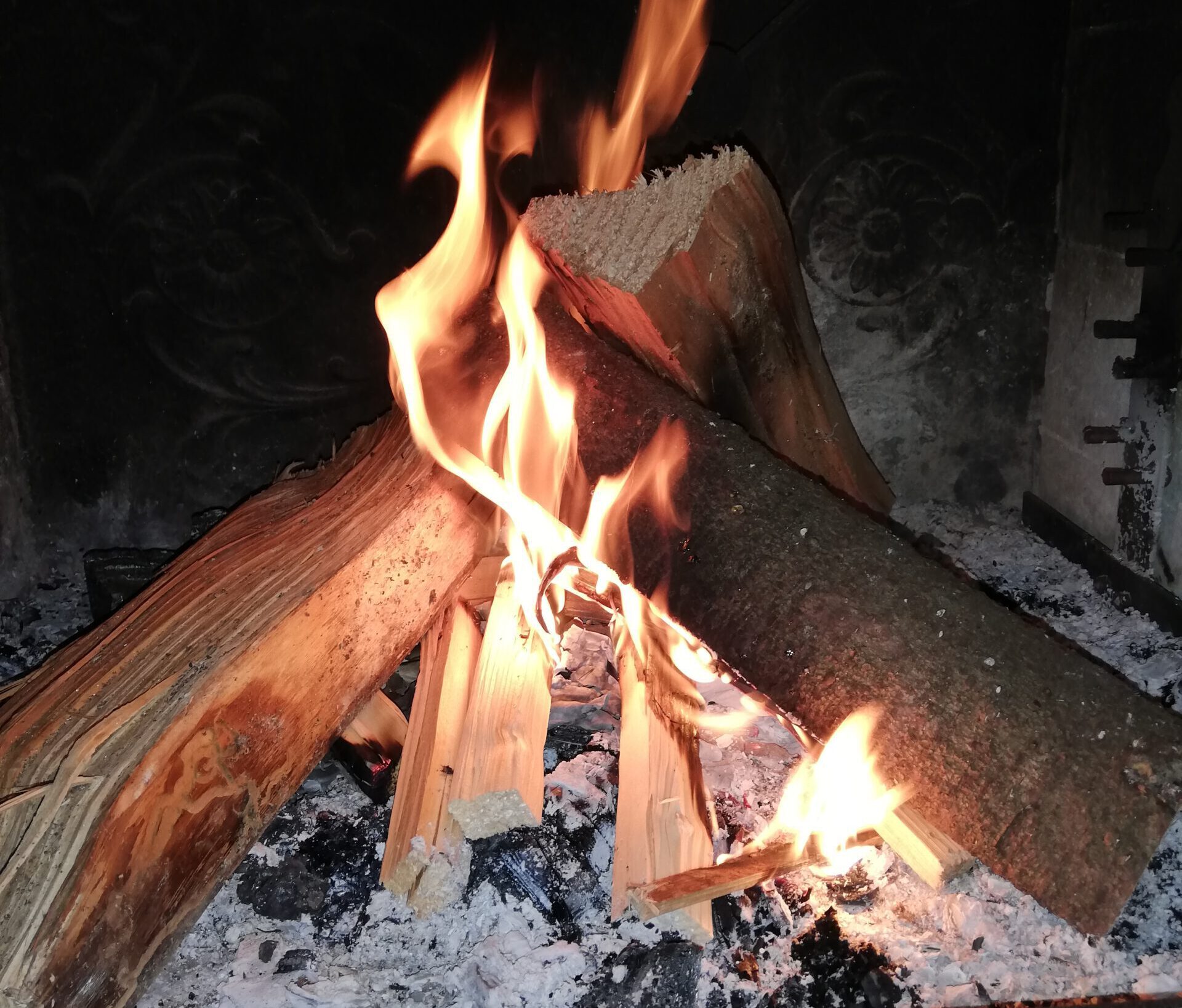 Ein Lagerfeuer bestehend aus drei Holzstücken bei Nacht